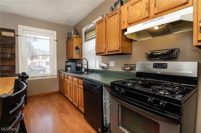 kitchen with sink, black appliances, a textured ceiling, and wood-type flooring