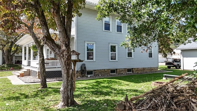 rear view of house featuring a porch and a yard