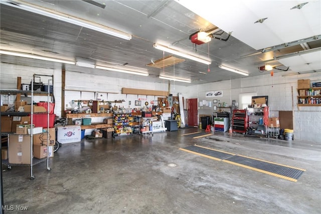 garage with a workshop area and a garage door opener