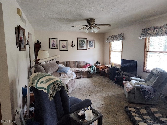 living room with ceiling fan, a textured ceiling, and carpet