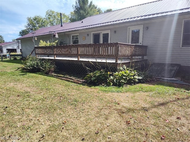 rear view of property with a wooden deck and a yard