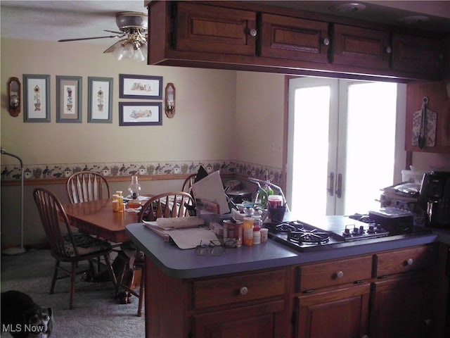 kitchen featuring carpet floors, stainless steel gas cooktop, ceiling fan, and french doors