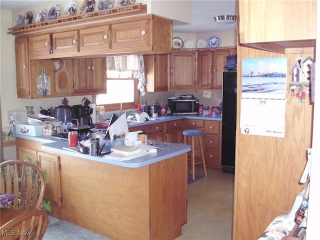 kitchen with black fridge and kitchen peninsula