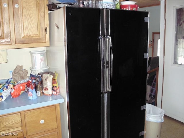 kitchen with black refrigerator and light brown cabinets