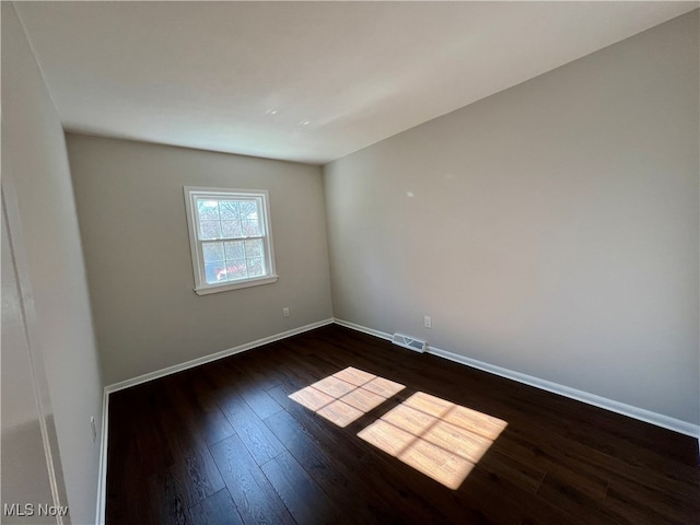 unfurnished room with dark hardwood / wood-style floors