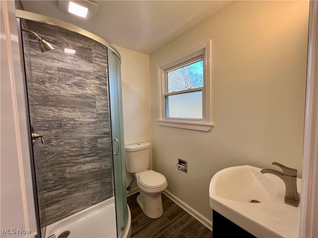 bathroom featuring wood-type flooring, vanity, toilet, and an enclosed shower