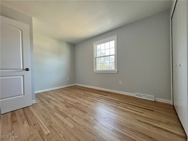 unfurnished bedroom with a closet and light hardwood / wood-style floors