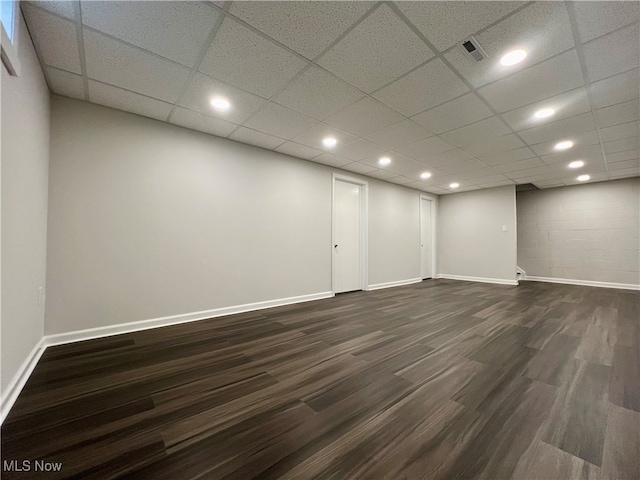 empty room featuring a drop ceiling and dark hardwood / wood-style flooring