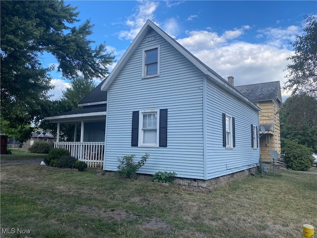 view of home's exterior featuring a porch and a yard