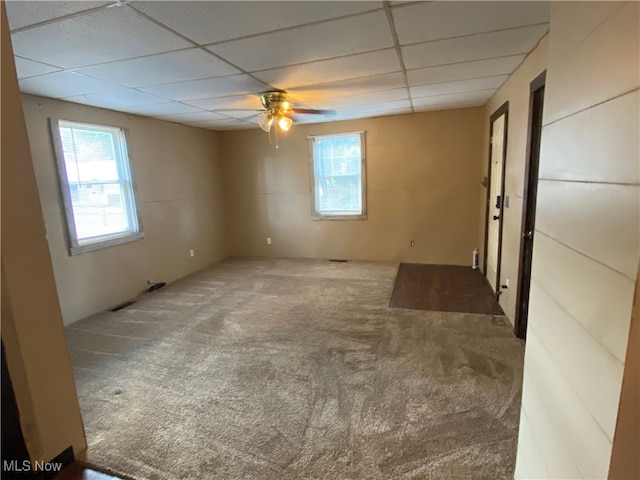 spare room featuring ceiling fan, a paneled ceiling, and carpet