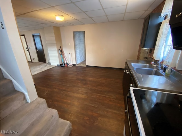 kitchen featuring range, dark wood-type flooring, stainless steel counters, a paneled ceiling, and sink