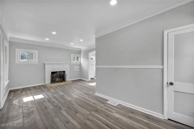 unfurnished living room featuring ornamental molding, a fireplace, and light hardwood / wood-style floors