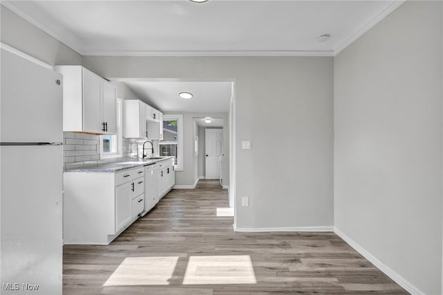 kitchen with light hardwood / wood-style floors, white cabinetry, white appliances, backsplash, and crown molding