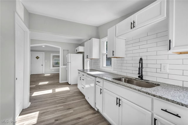 kitchen with decorative backsplash, light hardwood / wood-style floors, white cabinetry, white appliances, and sink