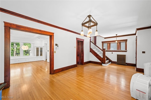 interior space with crown molding, light hardwood / wood-style floors, radiator, and an inviting chandelier