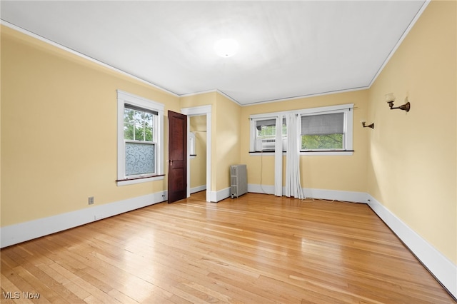 interior space featuring radiator, light hardwood / wood-style flooring, and ornamental molding