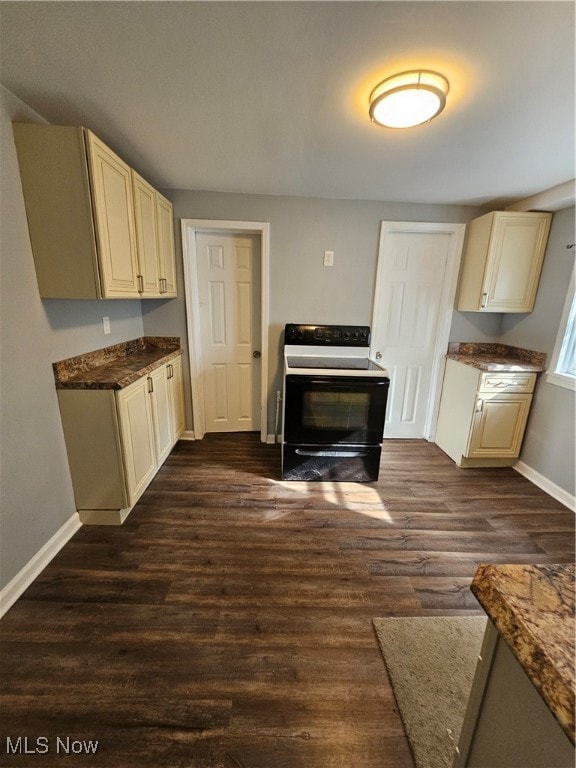 kitchen featuring white electric stove, cream cabinetry, and dark hardwood / wood-style flooring