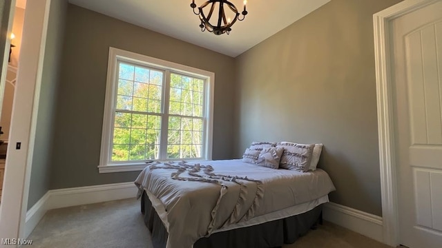 carpeted bedroom featuring lofted ceiling and a chandelier