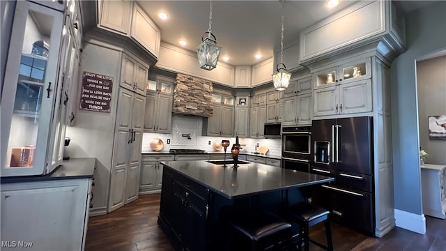 kitchen with a kitchen island, dark wood-type flooring, sink, appliances with stainless steel finishes, and tasteful backsplash