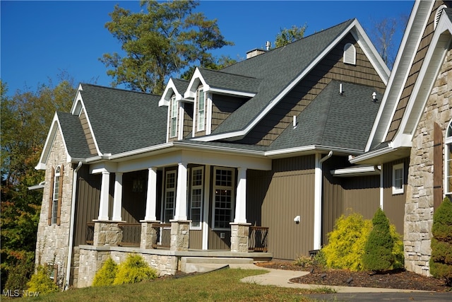 rear view of property featuring covered porch