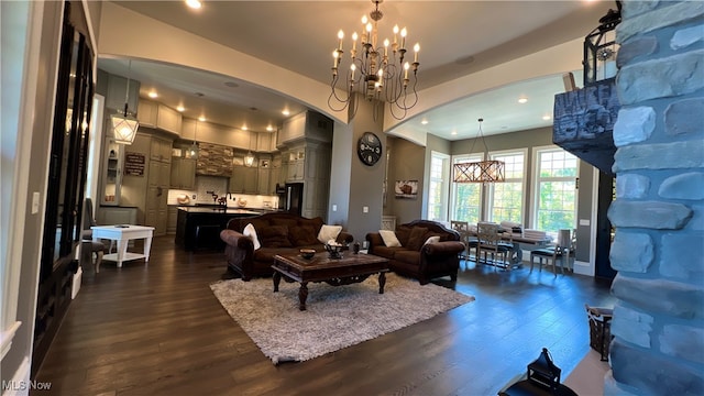 living room featuring an inviting chandelier and dark hardwood / wood-style floors