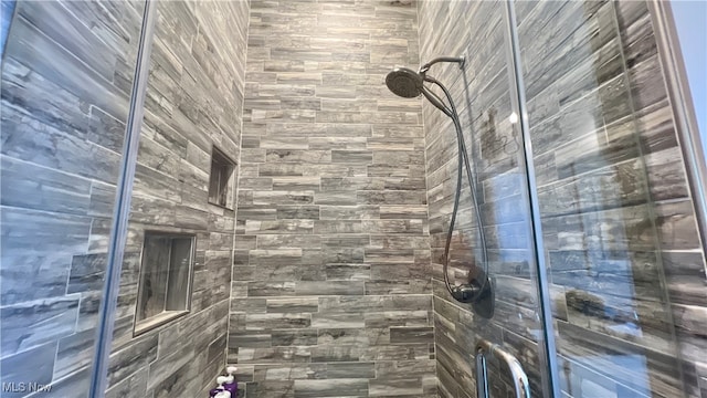 bathroom with a shower with door