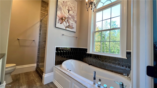 bathroom featuring backsplash, hardwood / wood-style floors, plus walk in shower, and toilet