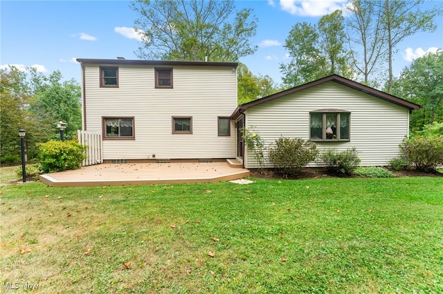 back of property featuring a deck, a patio, and a yard