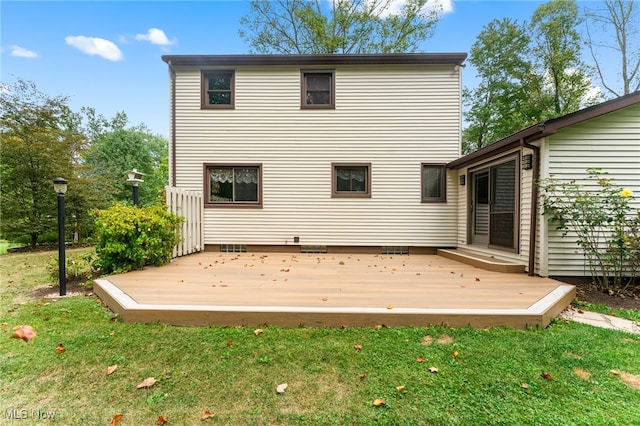 back of property with a deck and a yard