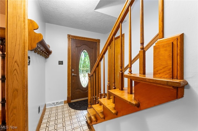 entryway with a textured ceiling