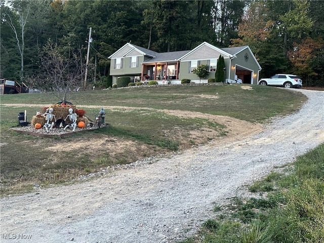 view of front of property featuring a porch, a garage, and a front yard