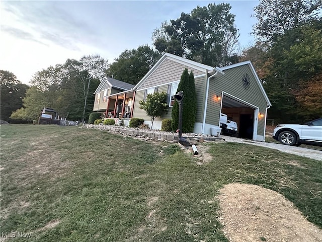 view of side of property featuring a yard, a porch, and a garage