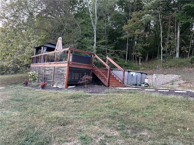 rear view of property featuring a deck and a lawn