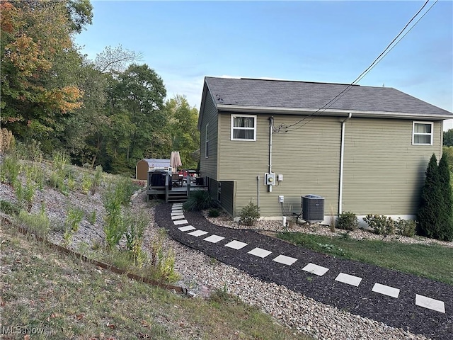 view of side of property featuring cooling unit and a wooden deck