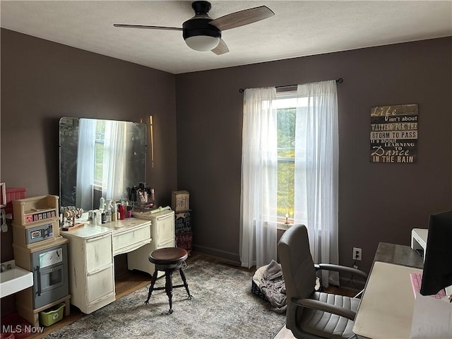 home office with hardwood / wood-style flooring and ceiling fan