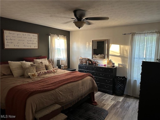 bedroom featuring ceiling fan, a textured ceiling, and hardwood / wood-style flooring