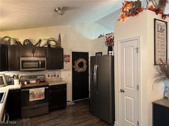 kitchen featuring dark hardwood / wood-style floors, lofted ceiling, stainless steel appliances, and tasteful backsplash