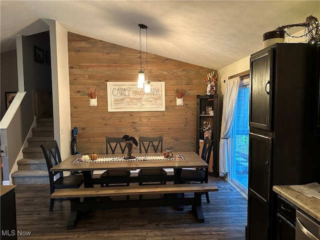 dining space with wood walls, dark hardwood / wood-style flooring, and lofted ceiling