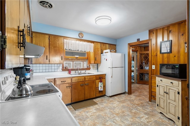 kitchen featuring white refrigerator, tasteful backsplash, sink, stainless steel stove, and exhaust hood