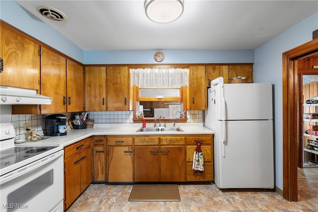 kitchen featuring sink, white appliances, and tasteful backsplash