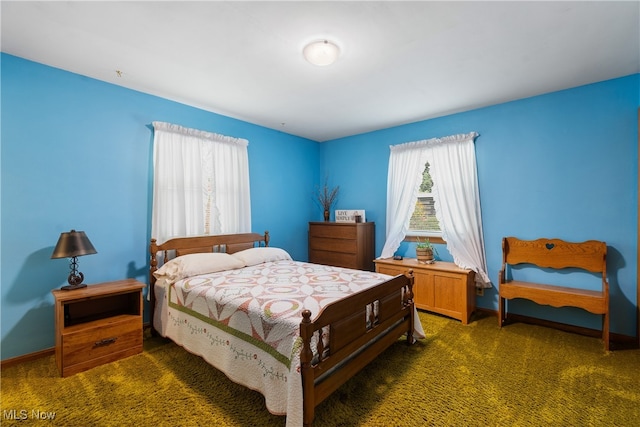 bedroom with multiple windows and dark colored carpet