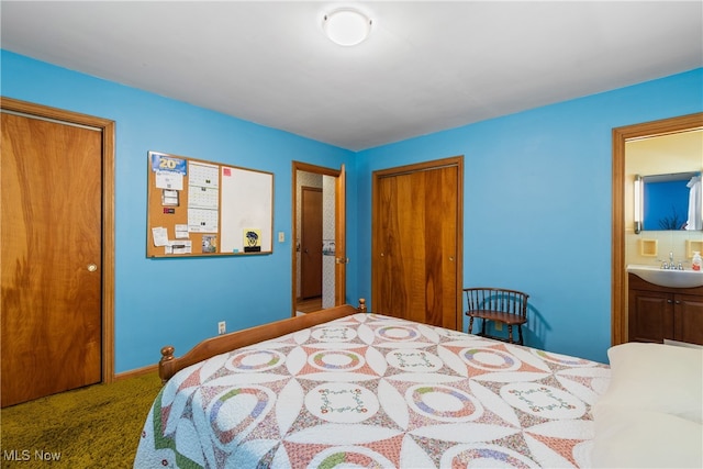 bedroom with ensuite bathroom, carpet flooring, and sink