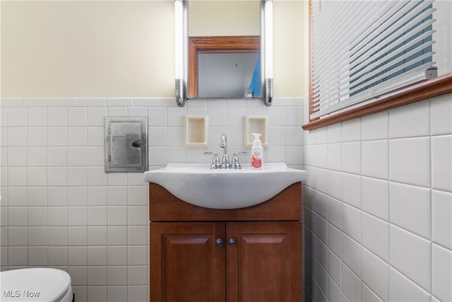 bathroom featuring tile walls, vanity, and toilet