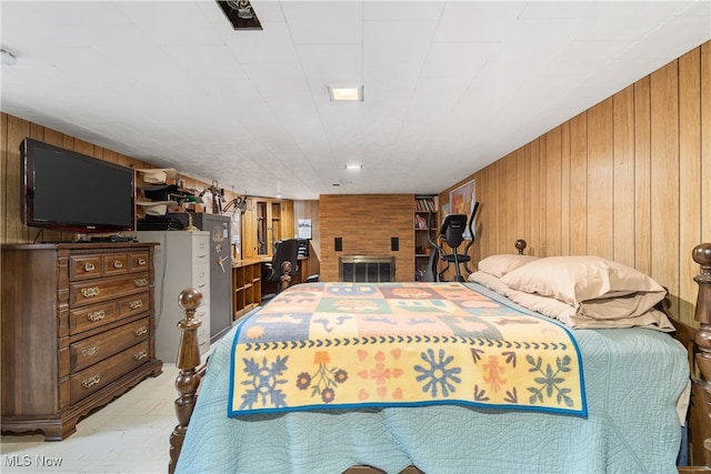 bedroom featuring a brick fireplace and wooden walls