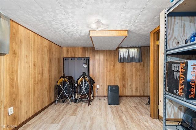 interior space with light hardwood / wood-style floors and wood walls