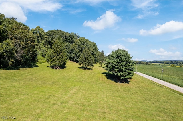 exterior space featuring a lawn and a rural view