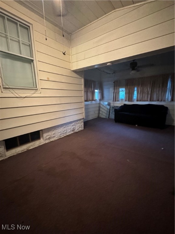 unfurnished living room with wooden walls