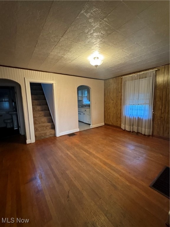 unfurnished living room featuring wood walls and hardwood / wood-style floors