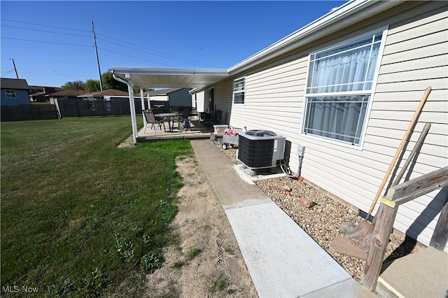 view of yard with central air condition unit and a patio