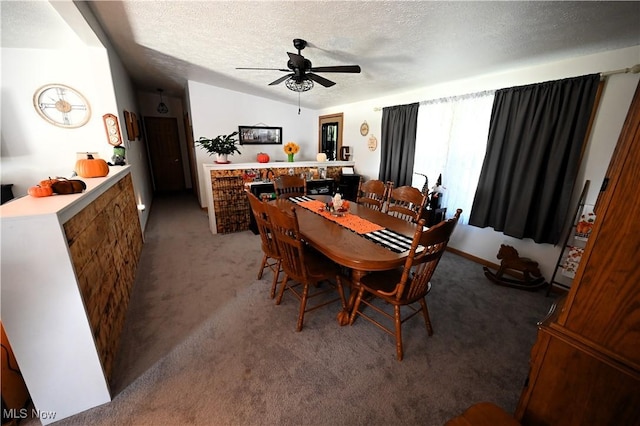 dining space with a textured ceiling, carpet floors, and ceiling fan